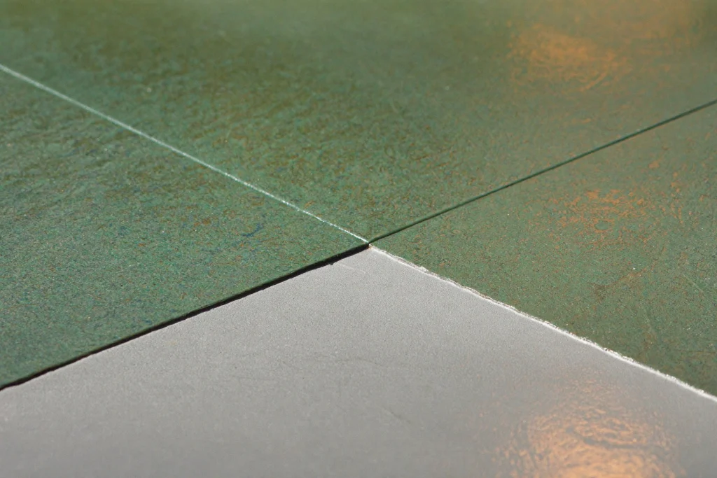 Bright green pigmented resin floor meeting grey along a crisp edge