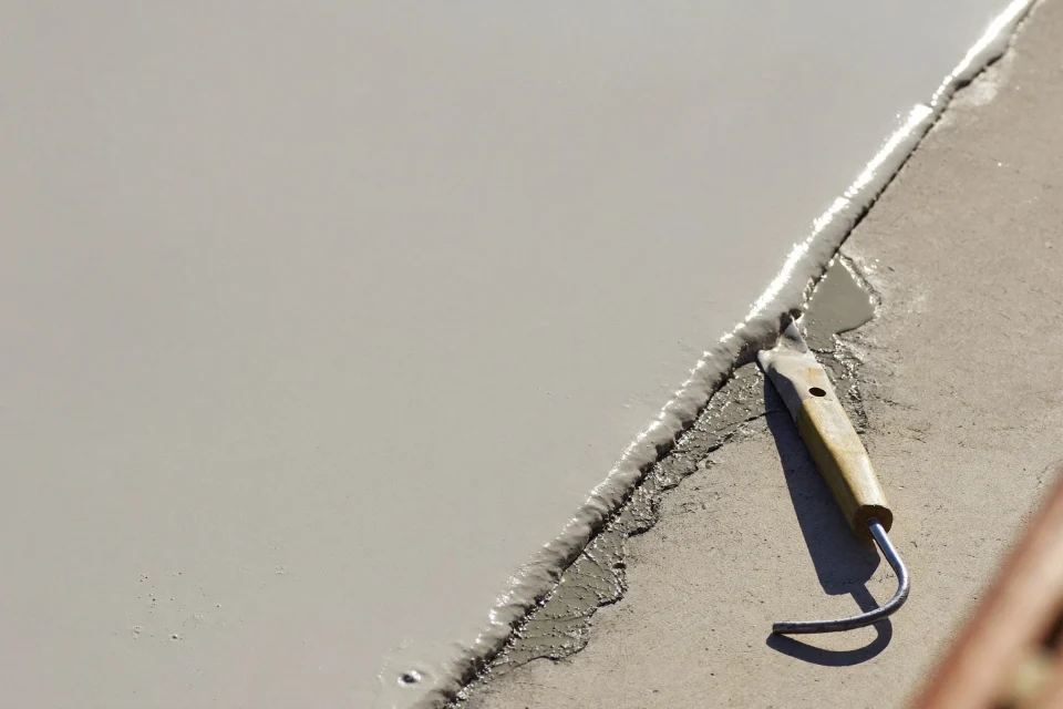 Raw concrete meeting a freshly sealed coating along a straight edge