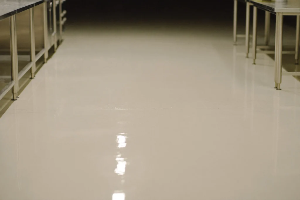 Fresh polyurethane-cement floor curing in an empty commercial kitchen at night