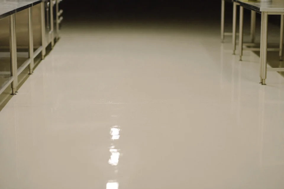 Fresh polyurethane-cement floor curing in an empty commercial kitchen at night